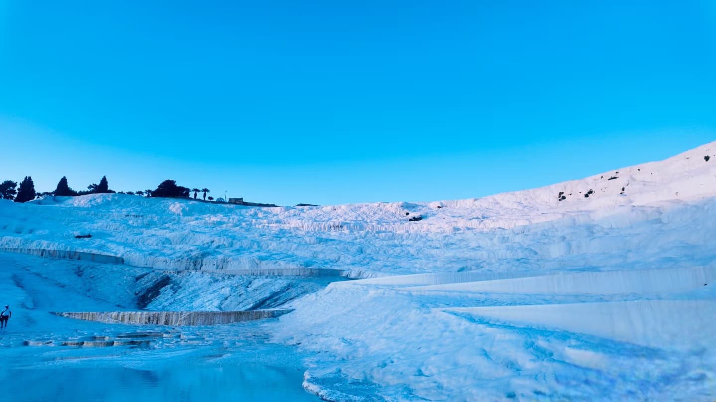 Wide view of Pamukkale travertine terraces under blue sky