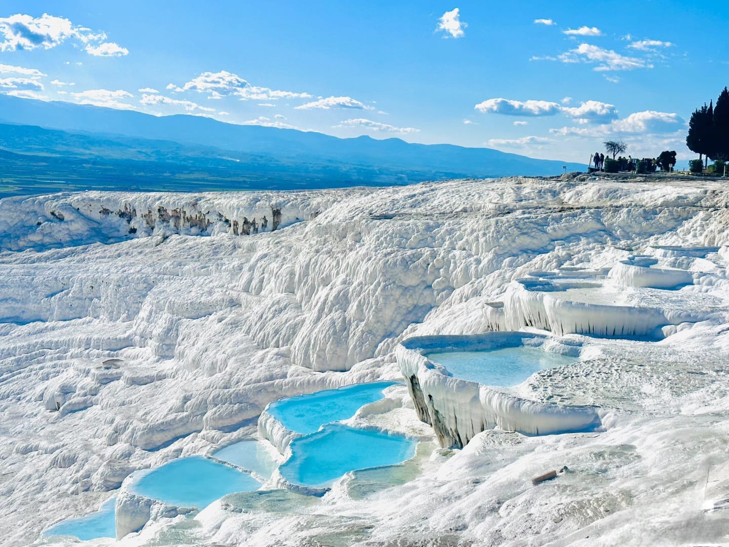 Pamukkale white travertine terraces and turquoise pools under cloudy sky